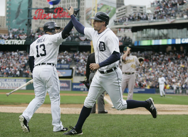 Don Kelly  is met at the dugout by teammate Alex Avila after scoring on a wild pitch 