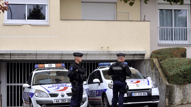 French Gendarmes stand in front of entrance of parking lot where "components useful for bomb-making" were found 