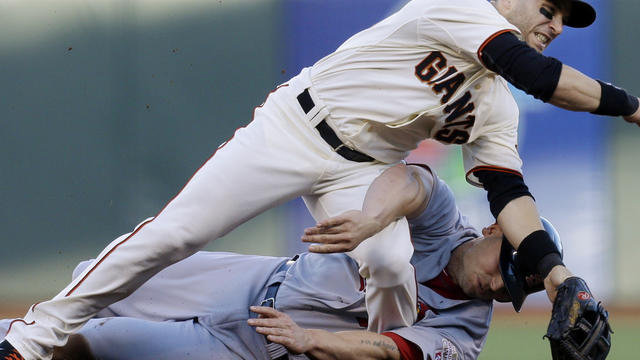 San Francisco Giants second baseman Marco Scutaro grimaces as his leg is caught under a sliding St. Louis Cardinals' Matt Holliday on a double play attempt during the first inning of Game 2 of baseball's National League championship series Monday, Oct. 15 