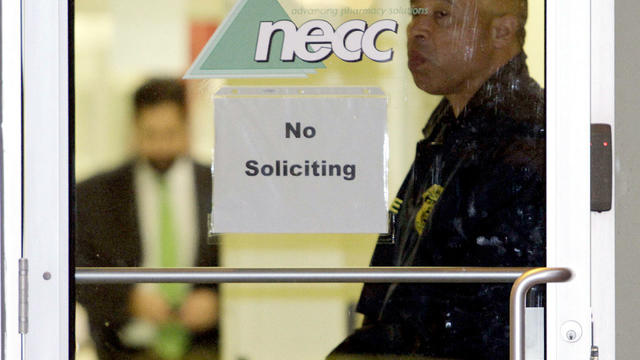 A Food and Drug Administration Agent stands at the doorway of New England Compounding Center in Framingham, Mass., Tuesday, Oct. 16, 2012, as investigators work inside. 