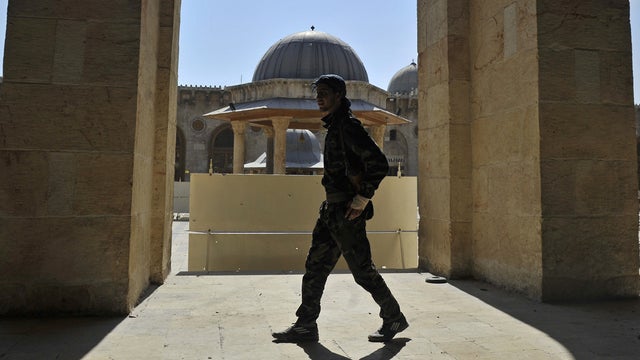 A Syrian rebel walks outside the Umayyad Mosque in Aleppo  