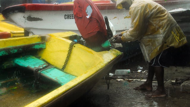 Fisherman Hubert Dowie works to secure his boat before the arrival of Hurricane Sandy in Port Royal, Jamaica, Oct. 24, 2012. 