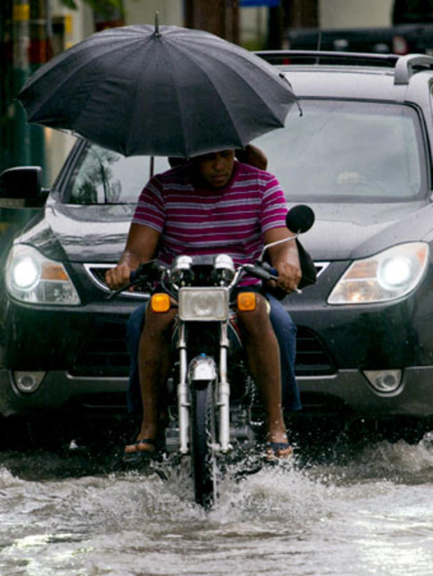 Locals ride a motorbike in a flooded street of Santo Domingo before the arrival of Hurricane Sandy on October 24, 2012.  