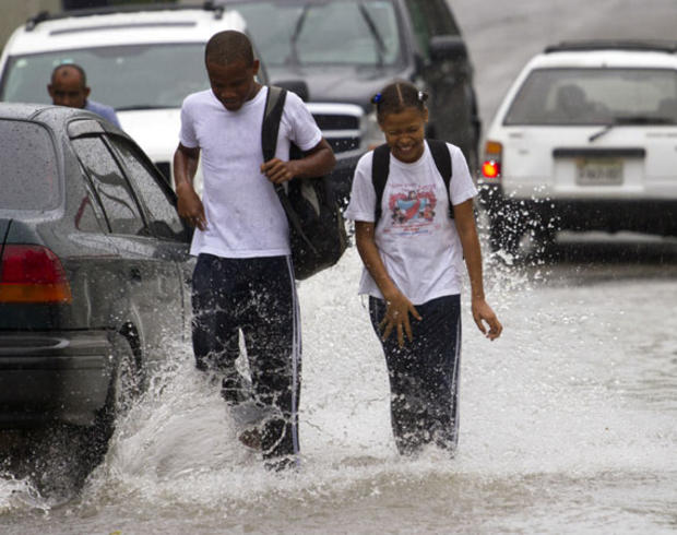 Dominican school children walk in the flooded streets of Santo Domingo before the arrival of Hurricane Sandy on October 24, 2012. The category one hurricane on the five-level Saffir-Simpson scale was forecast to dump up to 12 inches of rain across Jamaica 