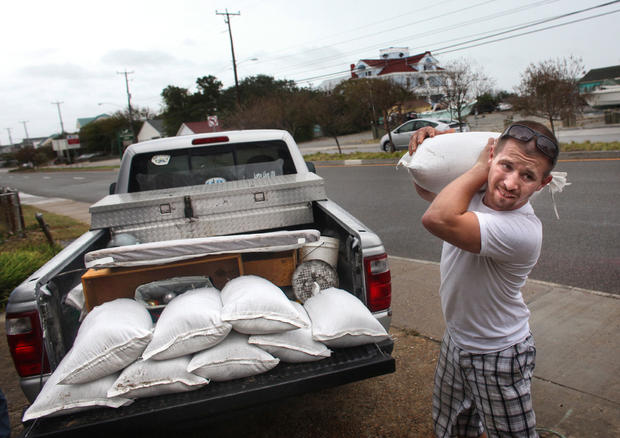 Nick Almeter, 26,  prepares for another storm, as he carries another sandbag to place by properties along Ocean View Avenue, in Norfolk, Va. 