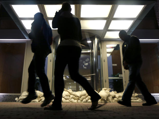 Sandbags line the entrance of a building as people walk by near the Hudson River waterfront Oct. 28, 2012, in Hoboken, N.J. 
