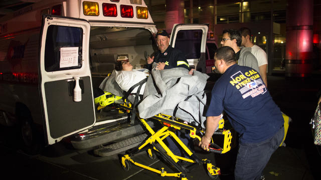 Medical workers assist a patient into an ambulance during an evacuation of New York University Tisch Hospital, after its backup generator failed when the power was knocked out by a superstorm, Monday, Oct. 29, 2012, in New York. Dozens of ambulances lined 