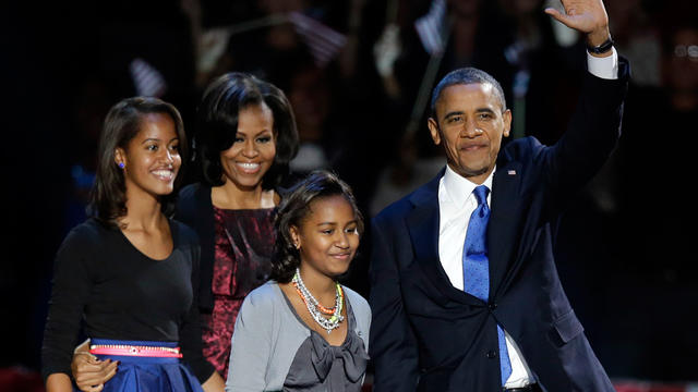 President Barack Obama waves as he walks on stage with first lady Michelle Obama and daughters Malia and Sash 