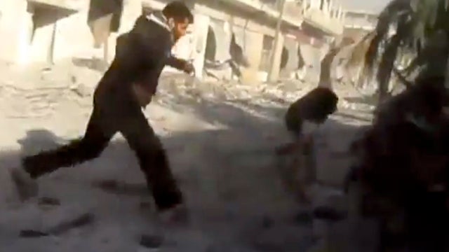 Men run during heavy bombing from military warplanes in Houla, Syria 
