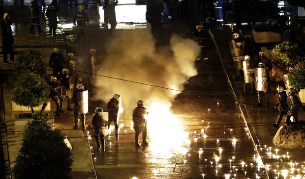A petrol bomb thrown by protesters explodes near riot police in front of parliament on Wednesday, Nov. 7, 2012, during clashes in Athens, Greece. 