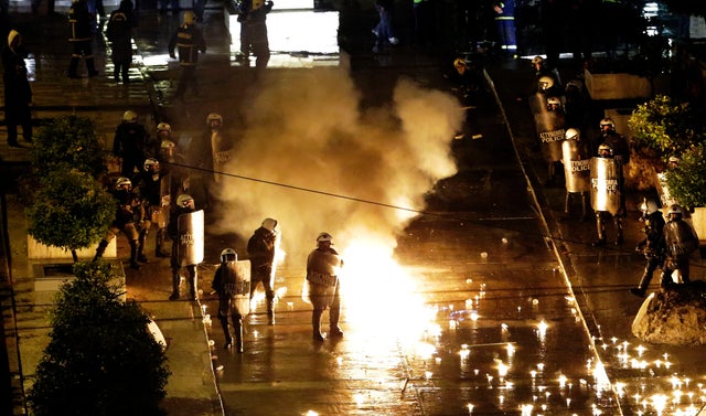 A petrol bomb thrown by protesters explodes near riot police in front of parliament on Wednesday, Nov. 7, 2012, during clashes in Athens, Greece. 