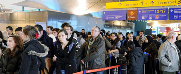 Passengers queue after flights have been 