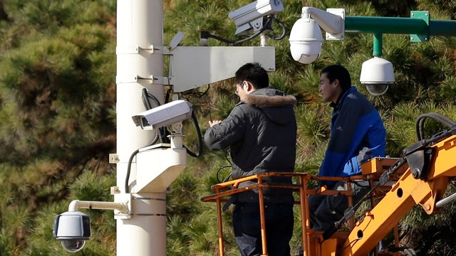 Workers check security cameras in Tiananmen Square, Beijing 