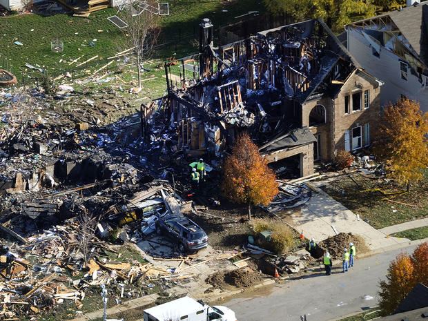 Citizens Energy workers continue their investigation Nov. 12, 2012, at the site of an explosion at a house in Indianapolis. 