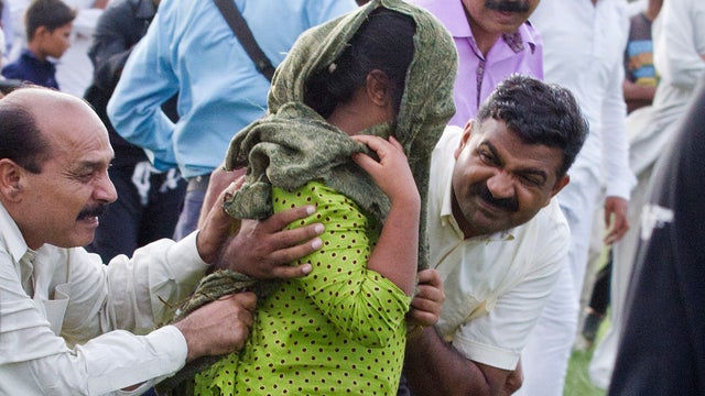 A young Christian girl accused of blasphemy is escorted to a helicopter after her release from prison 