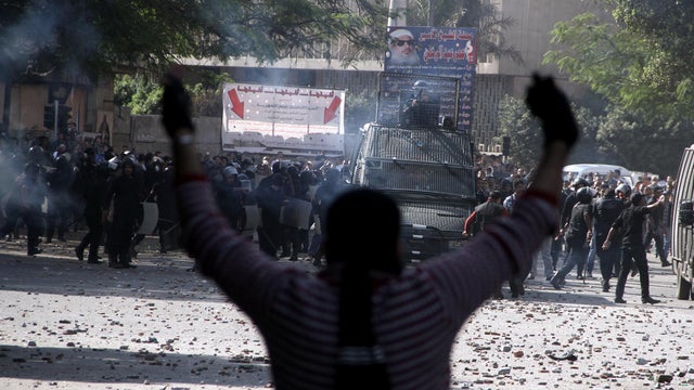 Egyptian security forces, background, clash with protesters near Tahrir Square in Cairo, Egypt, Sunday, Nov. 25, 2012. 
