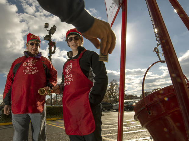Salvation Army bell ringer volunteers William Schmidt, who is on his 20th year volunteering, and grandson Bubba Wellens ring their bells as a donation is made into a kettle outside a Giant grocery store Nov. 24, 2012, in Clifton, Va. 