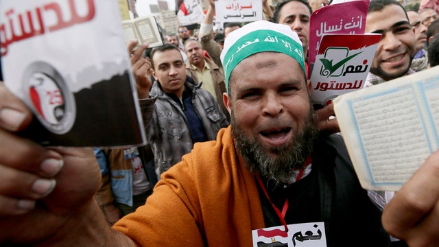Supporters of Egyptian President Mohammed Morsi chant slogans and hold up the Koran 