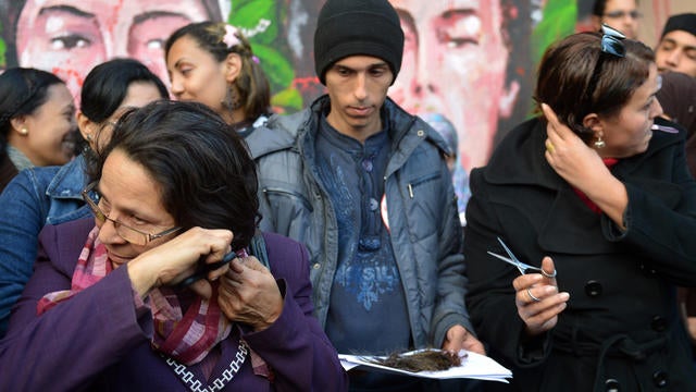 Egyptian female protesters cut their hair during demonstration,  mostly by Egytpian women, against their country's new constitution draft, on December 25, 2012 in Cairo's Tahrir square. 