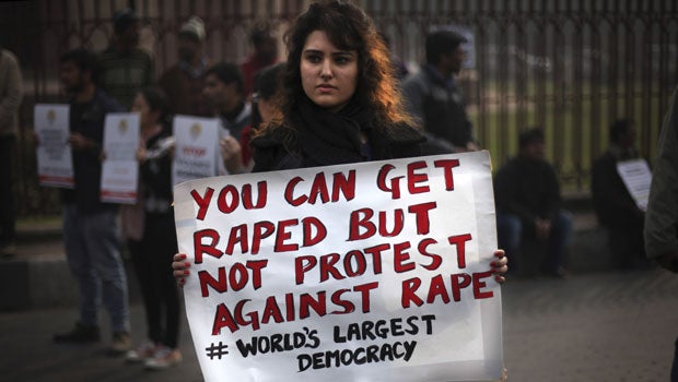 An Indian protester holds a placard during a protest against a recent gang rape of a young woman in a moving bus in New Delhi, India, Thursday, Dec. 27, 2012. 