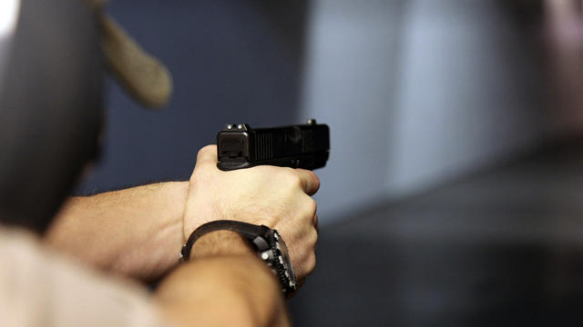 A man fires a handgun at Sandy Springs Gun Club and Range in Sandy Springs, Ga., Jan. 4, 2013. 