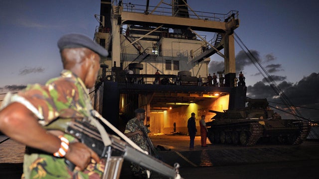Kenyan military officer keeps guard as Soviet made T-72 tanks are offloaded from the MV Faina ship at the port of Mombasa 