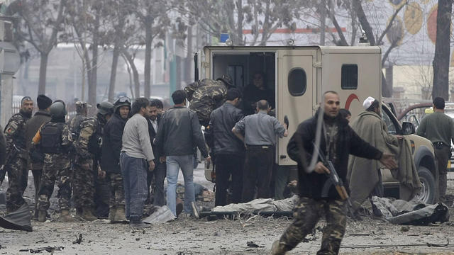 Afghans load victims into an ambulance at the scene of a suicide attack 