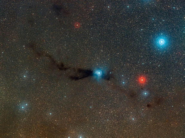 This wide-field view shows a dark cloud where new stars are forming along with cluster of brilliant stars that have already burst out of their dusty stellar nursery. This cloud is known as Lupus 3 and it lies about 600 light-years from Earth. 