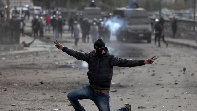 Egyptian protester flashes the victory sign during clashes with riot police 