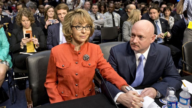 Former Arizona Rep. Gabrielle Giffords, who was seriously injured in the mass shooting that killed six people in Tucson, Ariz., two years ago, sits with her husband, Mark Kelly, on Capitol Hill in Washington, Wednesday, Jan. 30, 2013, prior to speaking be 