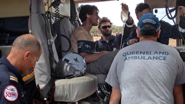 In this Feb. 15, 2013 photo, British teen Sam Derry-Woodhead, second left, sits in a rescue helicopter as he is tended to by ambulance personnel, near Upshot Station, a cattle ranch 55 miles from Longreach, Australia.  