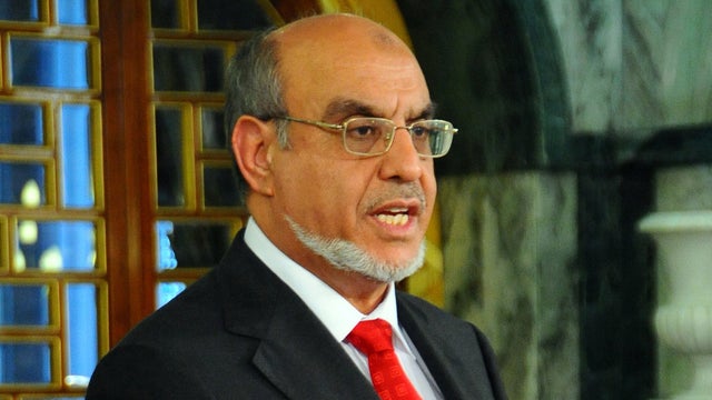 Tunisian Prime Minister Hamadi Jebali, holds the hand on the Koran as he takes the oath of office during a swearing-in ceremony at the presidential palace in Carthage near Tunis, Tunisia, Saturday, Dec. 24, 2011.  