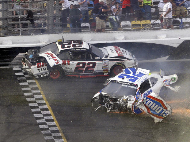 Brad Keselowski (22) and Kyle Larson (32) slide across the finish line after they were involved in a multi-car crash on the final lap of the NASCAR Nationwide Series auto race at Daytona International Speedway Feb. 23, 2013, in Daytona Beach, Fla. 