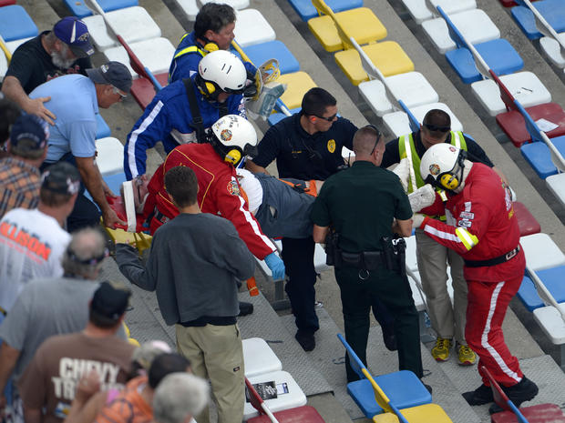 Emergency officials transport an injured spectator from the grandstands after Kyle Larson's car hit the safety wall and fence along the front stretch on the final lap of the NASCAR Nationwide Series auto race at Daytona International Speedway in Daytona B 