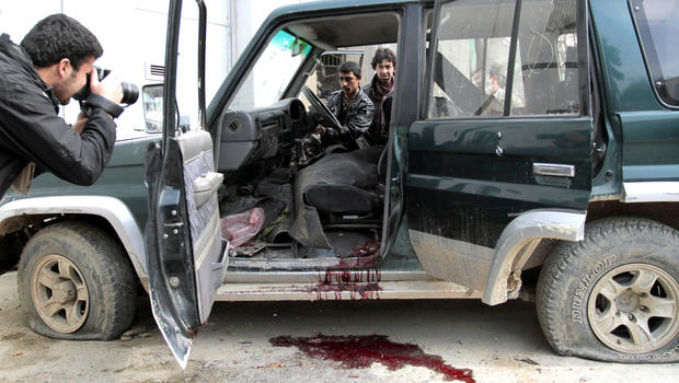 An Afghan intelligence officer, center, tries to turn on a vehicle used by an insurgent, who was killed by security forces, in Kabul, Afghanistan, Sunday, Feb. 24, 2013. 