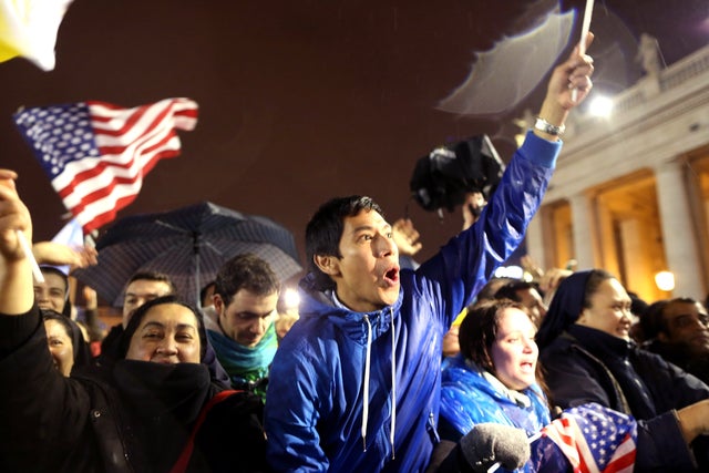 People jubilate as white smoke rises from the chimney on the roof of the Sistine Chapel  