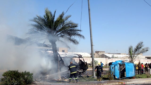 Iraqi firefighters douse the site of a blast in Baghdad's Shiite district of Sadr City on March 19, 2013. 