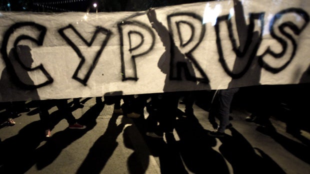 Protesters hold a banner during an anti- bailout rally outside of European Union house in capital Nicosia, Cyprus, Sunday, March 24, 2013.  