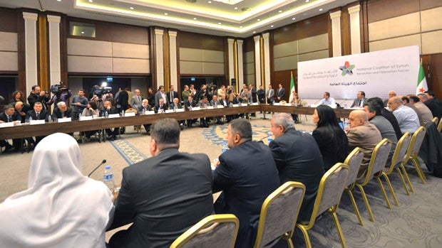 Head of the new Syrian National Coalition for Opposition and Revolutionary Forces Mouaz al-Khatib, rear-center, speaks during a meeting in Istanbul, Turkey, Monday, March 2013.  