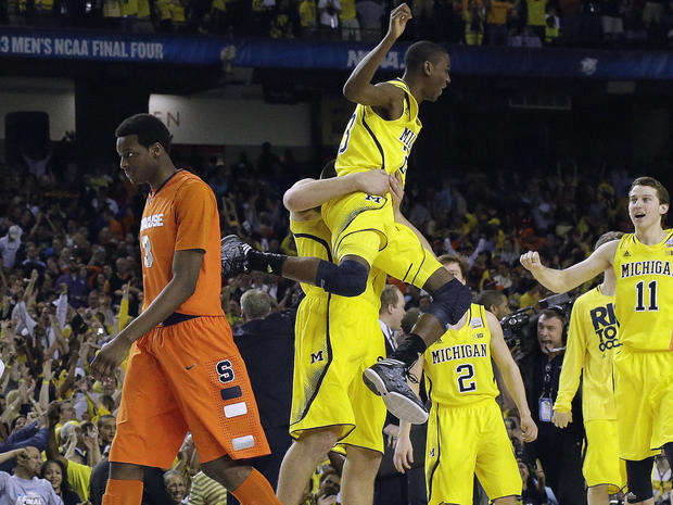 Michigan's Caris LeVert (23) celebrates with teammates as Syracuse's Jerami Grant (3) walks off the court during the second half of a NCAA Final Four tournament college basketball semifinal game April 6, 2013, in Atlanta. Michigan won 61-56. 