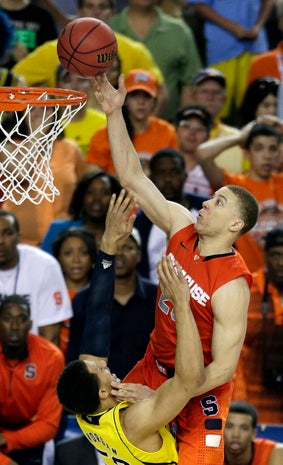 Syracuse's Brandon Triche (20) charges into Michigan's Jordan Morgan (52) during the second half of a NCAA Final Four tournament college basketball semifinal game April 6, 2013, in Atlanta. Triche was called for charging. 