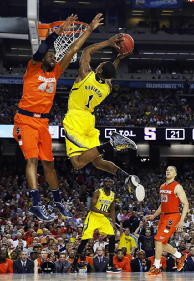 Michigan's Glenn Robinson III (1) shoots as Syracuse's James Southerland defends during the first half of a NCAA Final Four tournament college basketball semifinal game April 6, 2013, in Atlanta. 