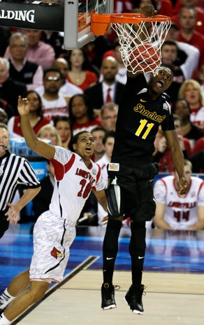 Louisville's Luke Hancock (11) dunks the ball against Louisville's Wayne Blackshear (20) during the first half of a NCAA Final Four tournament college basketball semifinal game April 6, 2013, in Atlanta. 