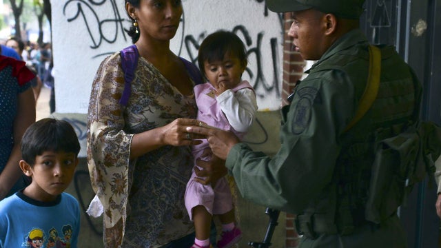 People line up to cast their vote at the Andres Bello polling station, in Caracas on April 14, 2013. Venezuelans headed to the polls on April 14 to elect Hugo Chavez's successor, with his political heir, Nicolas Maduro, hoping to continue his socialist re 
