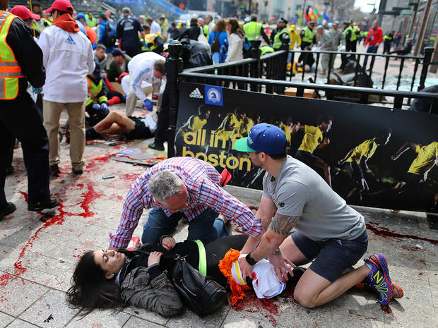 An injured woman is tended to at the finish line of the Boston Marathon, in Boston, Monday, April 15, 2013. Two explosions shattered the euphoria of the Boston Marathon finish line on Monday, sending authorities out on the course to carry off the injured  