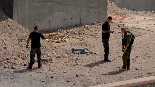 Israeli security agents investigate the scene of a rocket attack in Eilat 