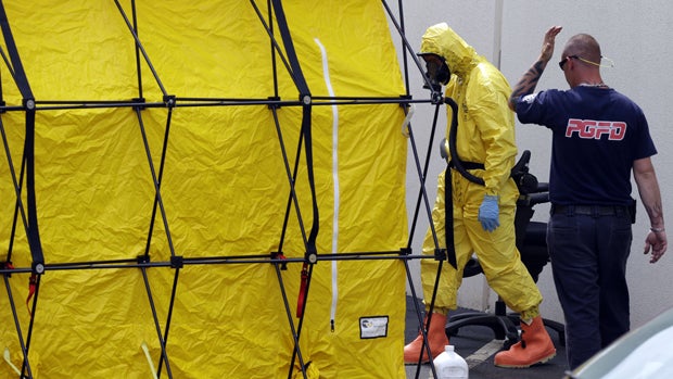 A Prince George's County, Md. firefighter dressed in a protective suit walks out of a government mail screening facility in Hyattsville, Md., Wednesday, April 17, 2013. 