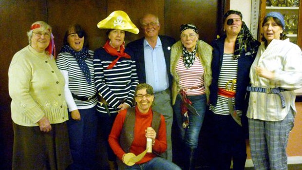Ladies of the Parkham Women's Institute in North Devon, England, pose with sea captain and writer Capt. Colin Darch. The Parkham WI had misinterpreted the context of the event and dressed up in eye patches and bandanas before learning Darch was coming to  