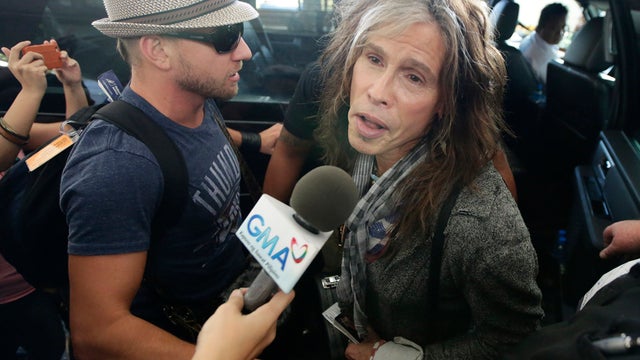 Aerosmith's Steven Tyler is mobbed by reporters as he makes his way to waiting van upon arriving from Melbourne May 5, 2013 in Manila, Philippines. Tyler and his entourage were there as part of their band's world tour concert. 