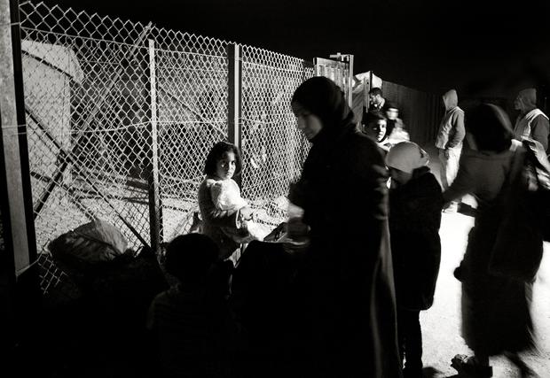 Refugees wait to be processed by UNHCR staff after arriving in the night to the Zaatari refugee camp 